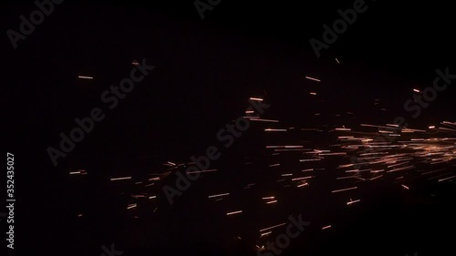 Fiery sparks from fireworks on black background