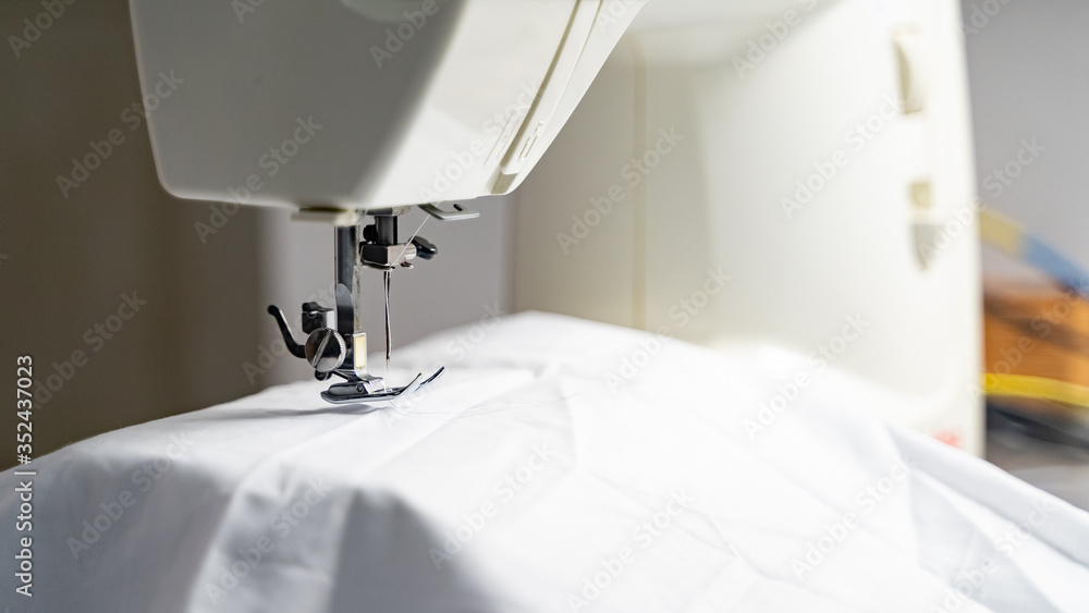 Electric sewing machine with fabric and thread