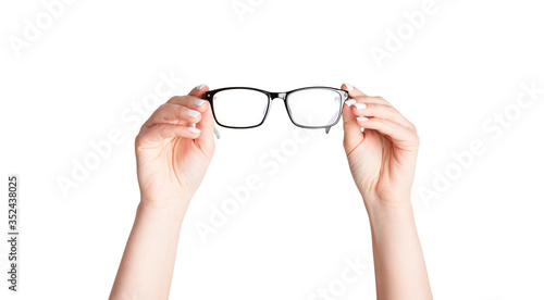 Closeup of young woman holding eyeglasses on white background. Panorama