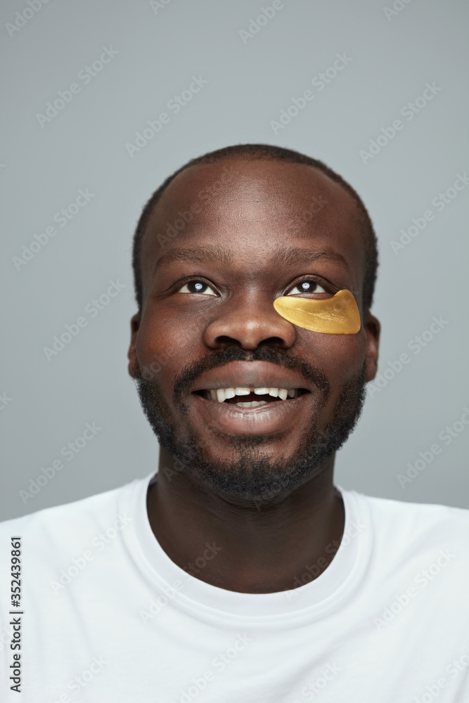 Obraz premium Skin Care. Portrait Of Male Model Applying Yellow Under Eye Patches. Beauty Cosmetic Mask On Face. Face Care Routine. Cosmetology Facial Treatment.