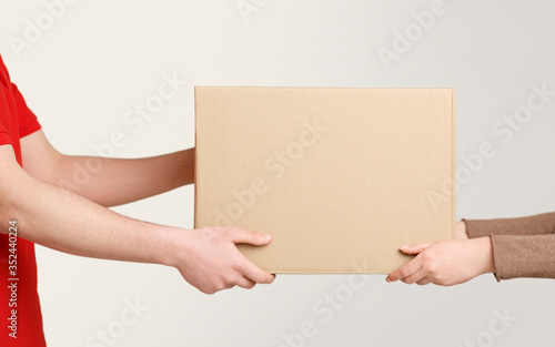 Woman hands accepting delivery of box from deliveryman