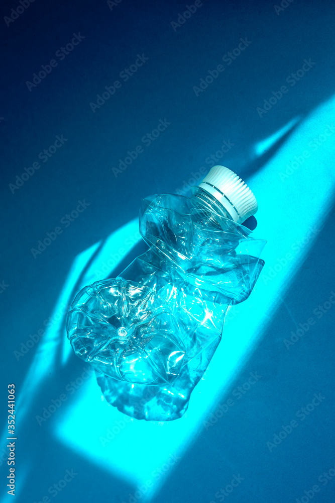 Transparent plastic bottle on a solid blue background for recycle waste. Waste separation concept.Protect the environment. Garbage processing. Preserve nature. Selective focus.