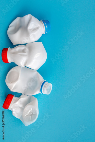 White plastic bottle on a solid blue background for recycle waste. Waste separation concept. Protect the environment. Secondary raw material. Sorting garbage concept. Selective focus.