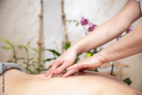 Young woman relaxing during back massage at the spa