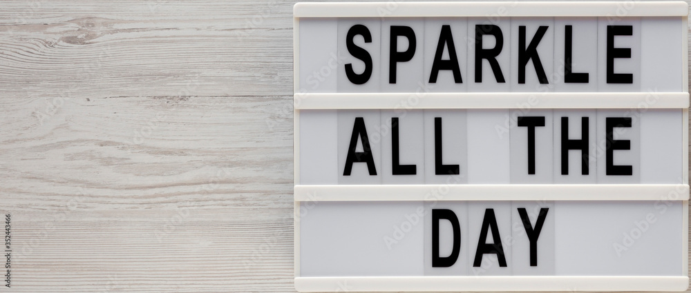 'Sparkle all the day' words on a lightbox on a white wooden surface, top view. Overhead, from above, flat lay. Copy space. 'Sparkle all the day' words on a lightbox on a white wooden surface, top view. Overhead, from above, flat lay. Copy space.