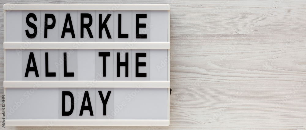 'Sparkle all the day' words on a modern board on a white wooden surface, top view. Overhead, from above, flat lay. Copy space. 'Sparkle all the day' words on a modern board on a white wooden surface, top view. Overhead, from above, flat lay. Copy space.