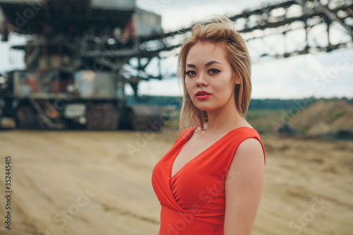 Beautiful asian girl in red dress posing on industry giant background