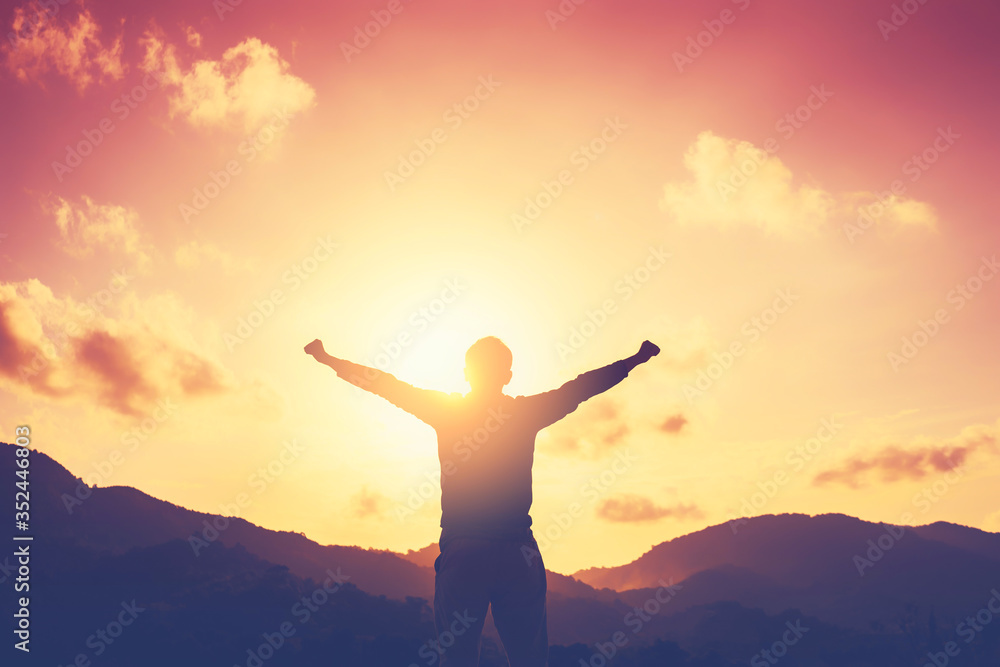 Copy space of man rise hand up on top of mountain and sunset sky abstract background.