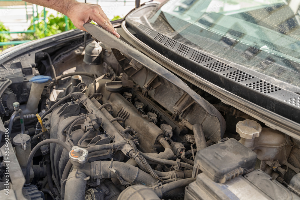 Auto mechanic works in the garage. Repair. Removing engine cover for oil change. Auto mechanic works in the garage. Repair. Removing engine cover for oil change.