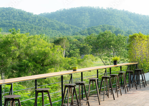 chairs and long table on terrace with landscape mountain and trees