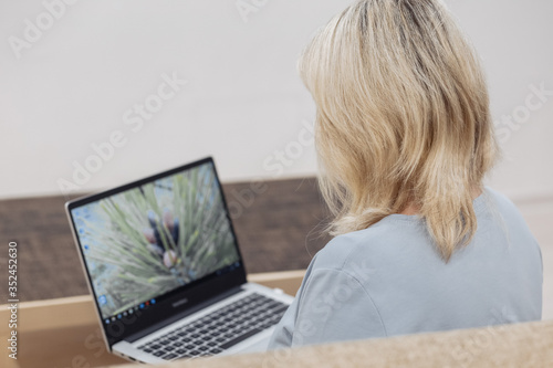 Middle-aged woman working on laptop from home, close up hands