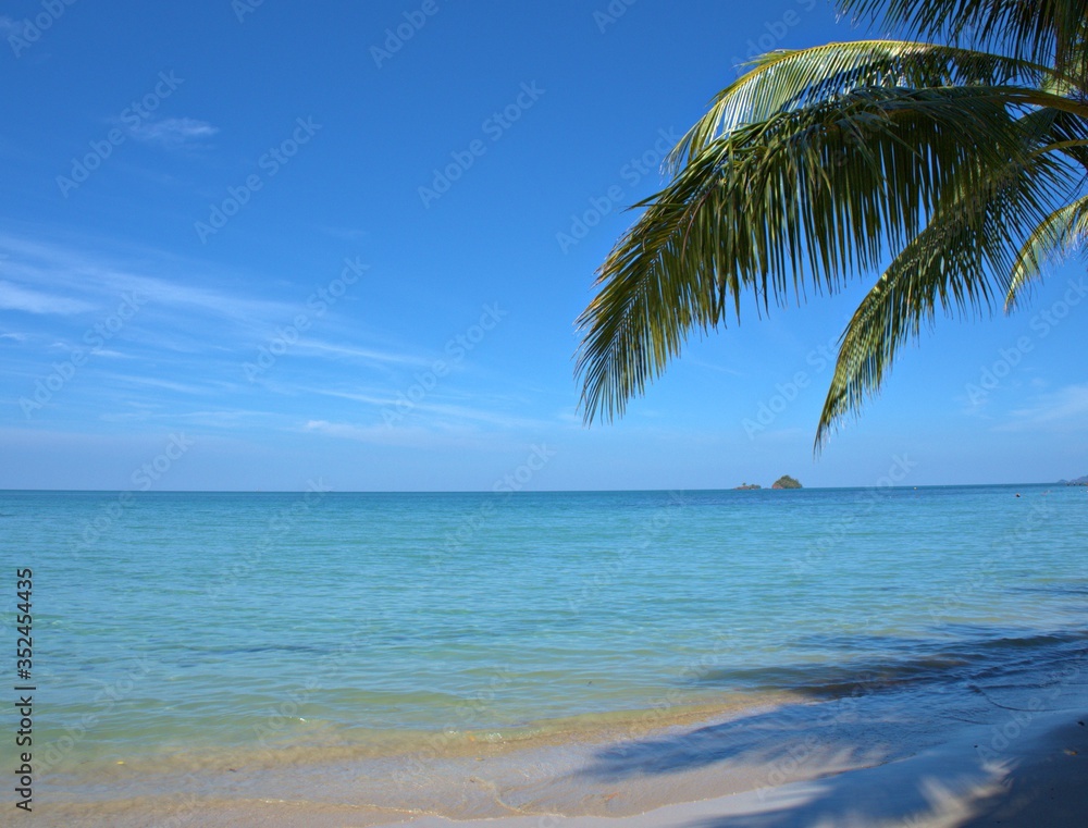 Beautiful sand beach with blue sky cloud ,splash sea water with coconut tree for background and wallpaper, summer holiday at  Koh Chang island ,Thailand