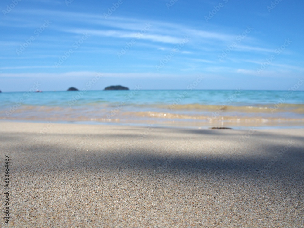 Obraz premium Beautiful white sand beach with blue sky cloud , for background and wallpaper, splash water ,sea wave, summer holiday at koh Chang island Thailand 
