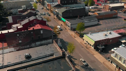 Downtown one-way city street with vehicular traffic, Newport, Kentucky, overhead approaching aerial parallax