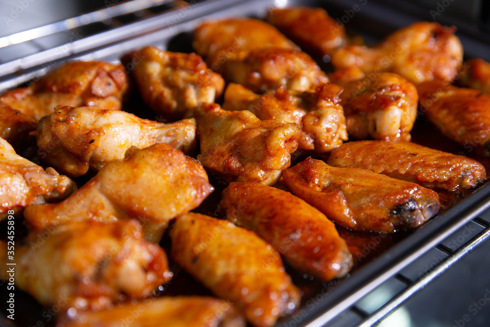 Chicken wings baked on a stainless steel tray in the microwave. Chicken wings baked on a stainless steel tray in the microwave.