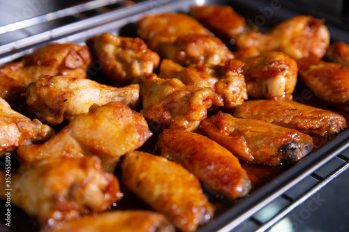 Chicken wings baked on a stainless steel tray in the microwave.