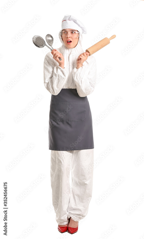 Troubled housewife in protective costume and with kitchen utensils on white background Troubled housewife in protective costume and with kitchen utensils on white background