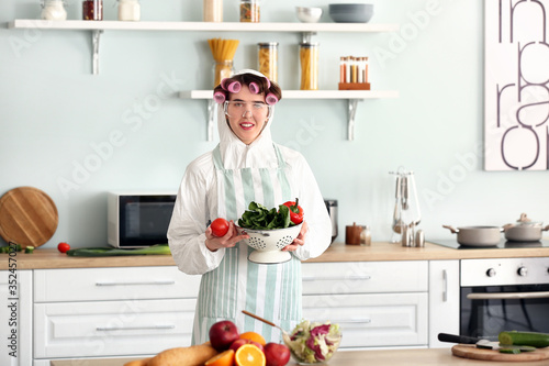 Housewife in protective costume cooking in kitchen