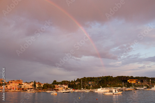 Rainbow in the sky over the town of Rovinj, Croatia, with the Adriatic Sea and some boats sailing