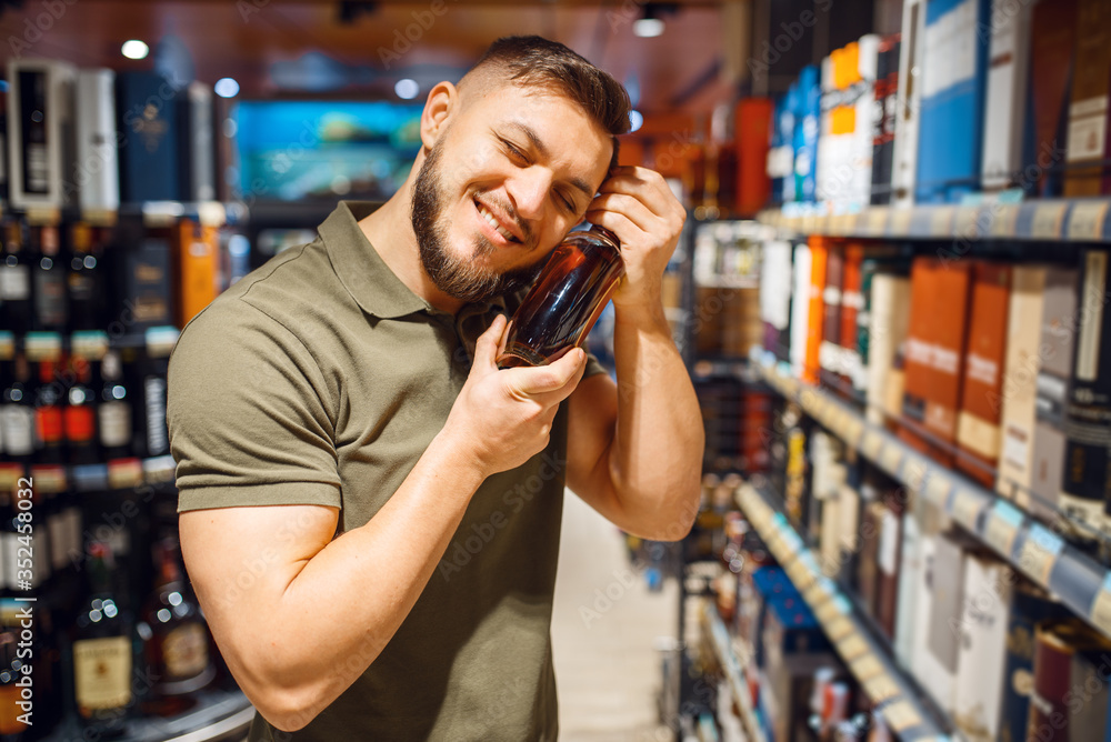 Man hugs bottle of alcohol in grocery store