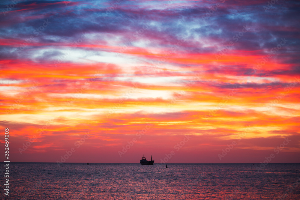 Cargo ship with containers in sunrise light