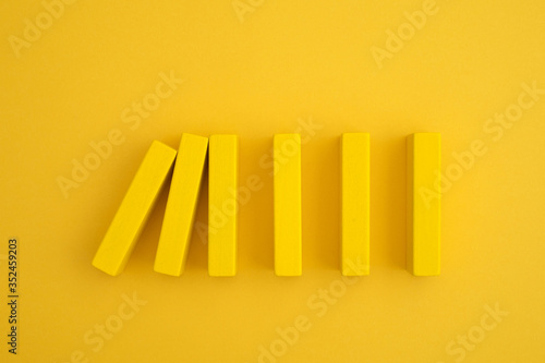 Fotografie yellow domino block beginning to fall
