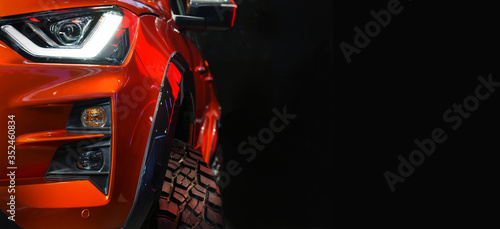 Close up detail on one of the LED headlights red Pickup Truck on black background,copy space