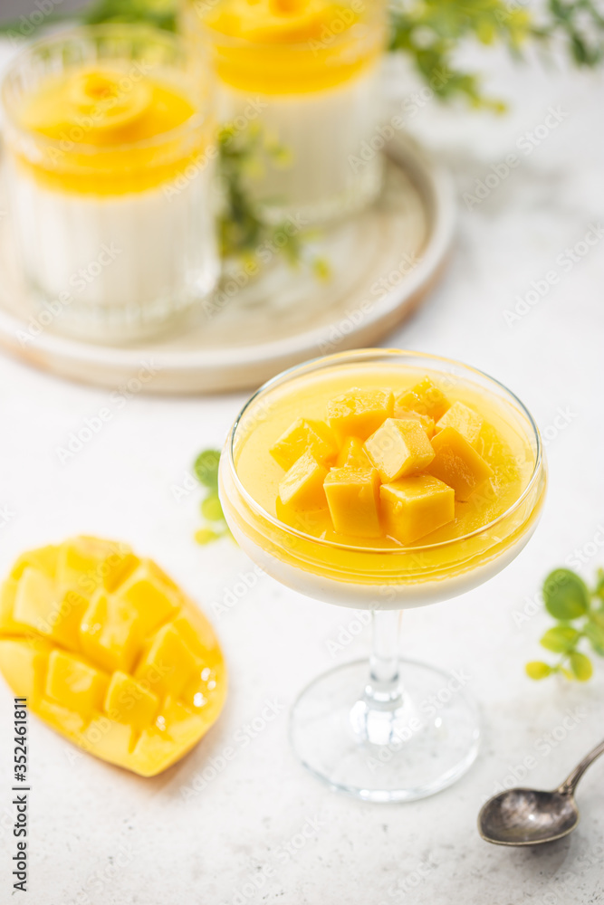Italian dessert panna cotta with mango in glass on white background Italian dessert panna cotta with mango in glass on white background