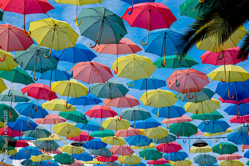 Umbrellas floating in the sky with lots of color