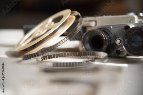 8mm movie roll of film reel with a retro movie camera on a light table. Filming Accessories