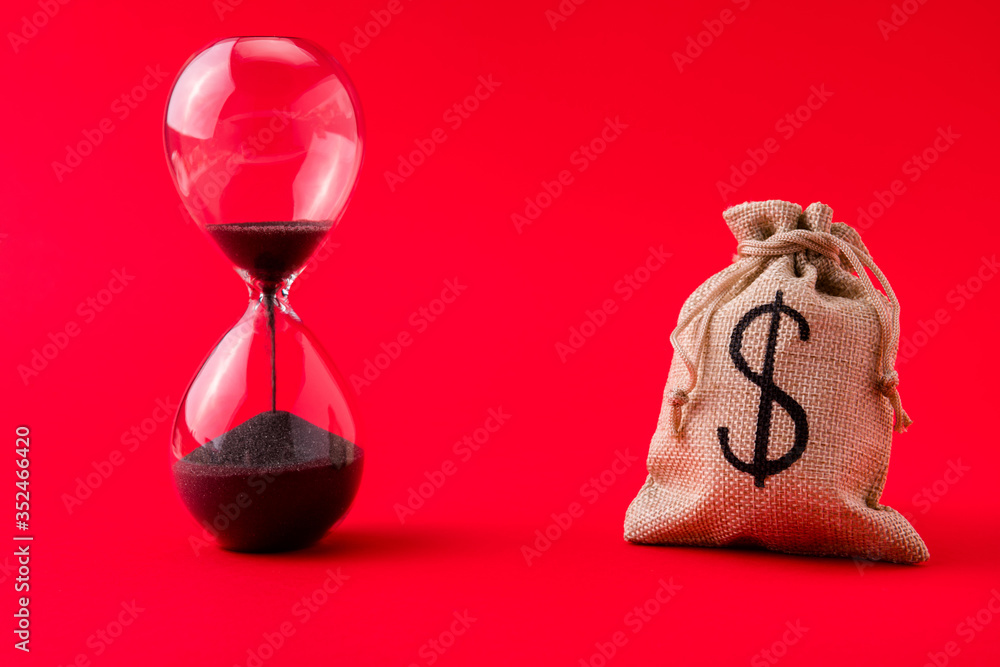 Close-up view of moneybag account market management stocks shares rate running out of time sand clock counting isolated over bright vivid shine vibrant red color background - obrazy, fototapety, plakaty 