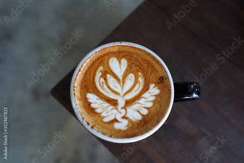 Close up Latte coffee art cup on wooden table