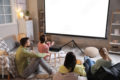 Bild auf Leinwand Young friends watching movie at home