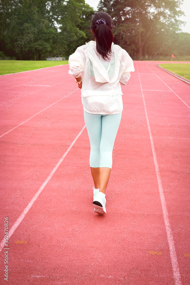 Athlete runner running on athletic track, jogger jogging in the stands of a track and field stadium for competition race, sport woman training and doing exercise outdoor