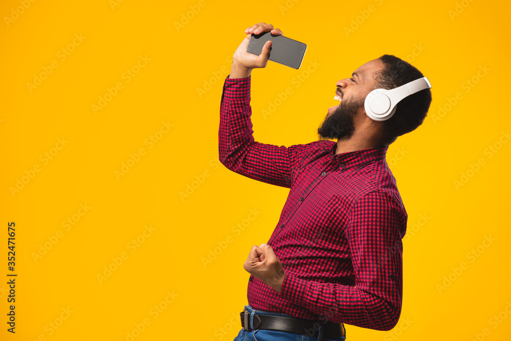 Afro man singing using smartphone as microphone Afro man singing using smartphone as microphone