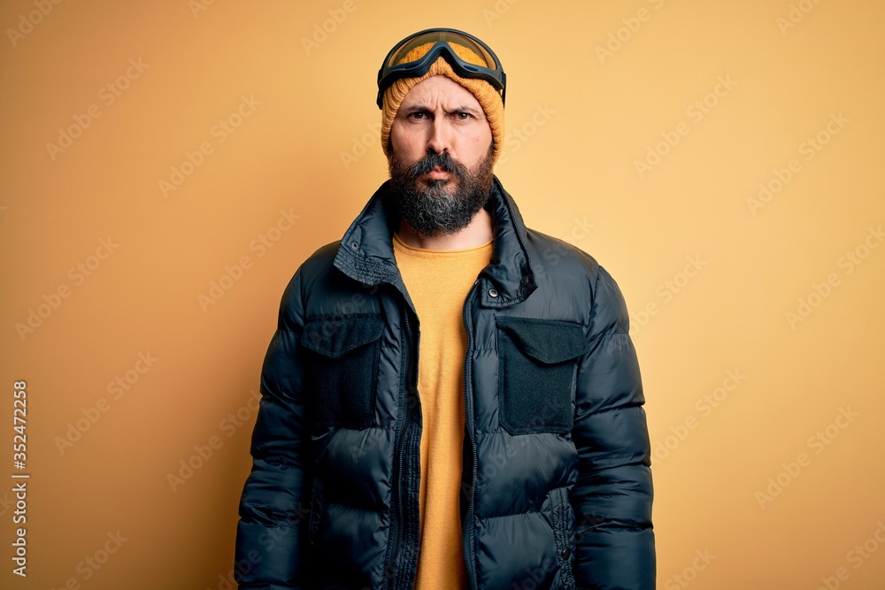 Handsome skier bald man with beard skiing wearing snow sportswear and ski goggles depressed and worry for distress, crying angry and afraid. Sad expression. Handsome skier bald man with beard skiing wearing snow sportswear and ski goggles depressed and worry for distress, crying angry and afraid. Sad expression.