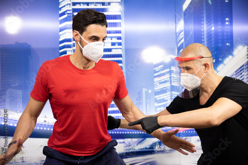 Joven entrenando con los EPIs colocados (equipos de protección personal), consistente en guantes mascarilla y pantalla por el virus COVID-19 photo