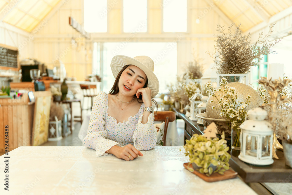 Portrait of stylish young woman in dress vintage style and hat sit posing in the coffee shop decoration in vintage style