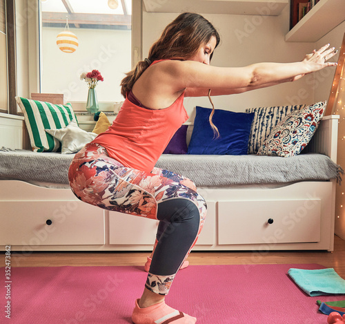 Pregnant beautiful woman doing Yoga/Pilates at home.