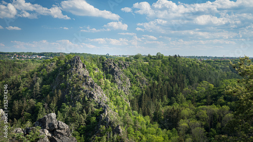 Nature reserve Divoka Sarka (Wild Sarka) in Prague on a spring day. Blue sky, green trees and steep rocks in a valley seen from elevated viewpoint. Beautiful hidden place for relaxation in the city photo