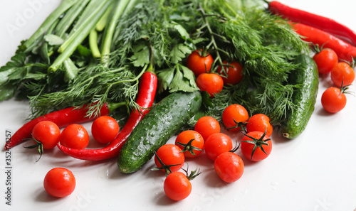 chili peppers, cucumbers, cherry tomatoes and herbs on a white background