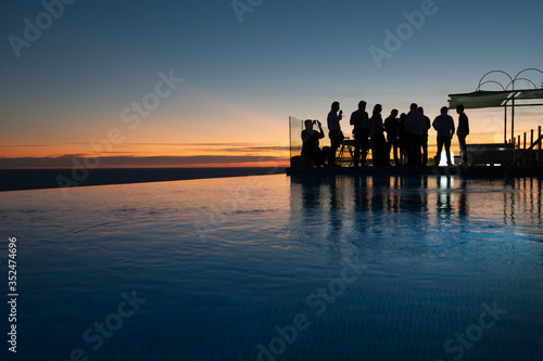 amazing situation silhouette of business people backlight in swimming pool at sunset with space to write