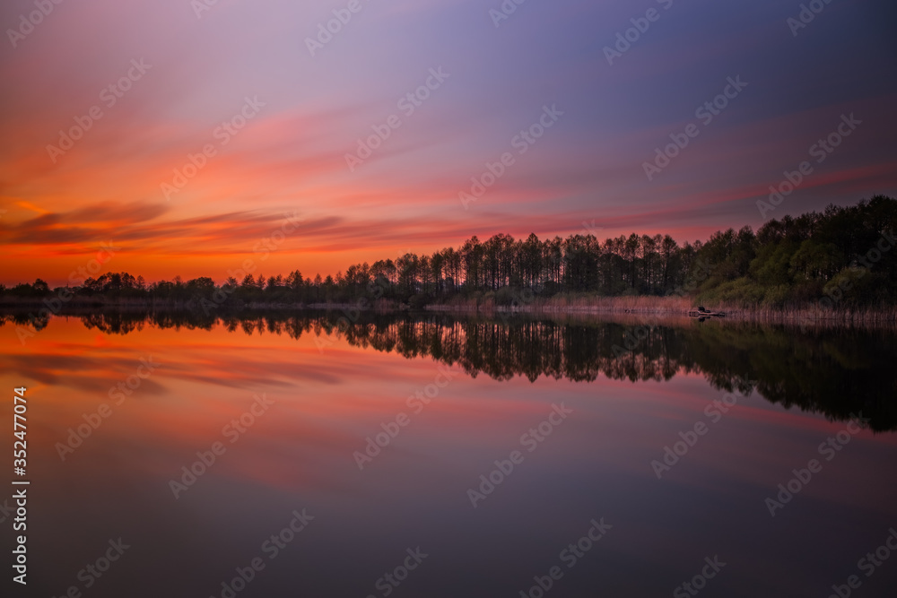 Long exposure sunset evening view on Sukhovilske Lake and forest in Sukhovolia, Rudno. Lviv district, Ukraine. May 2020