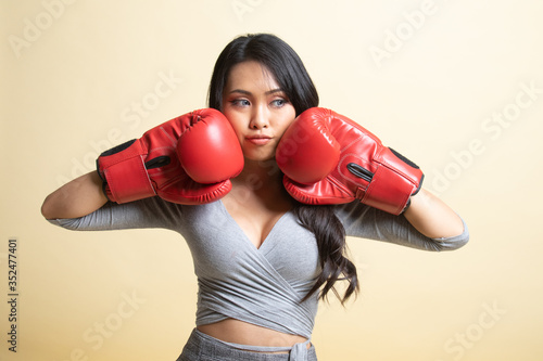 Young Asian woman with red boxing gloves.