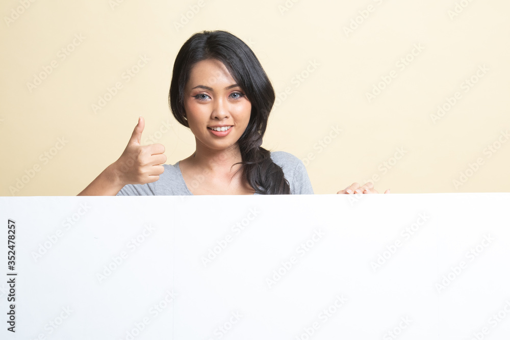 Young Asian woman show thumbs up with blank sign. Young Asian woman show thumbs up with blank sign.
