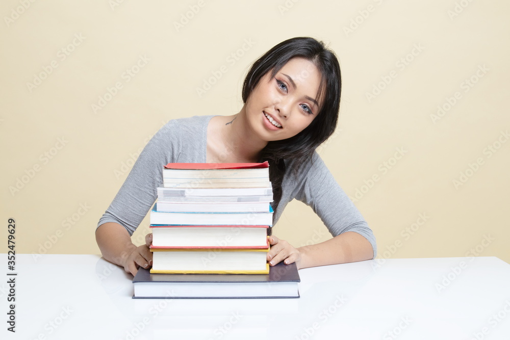 Happy young Asian woman read a book with books on table. Happy young Asian woman read a book with books on table.