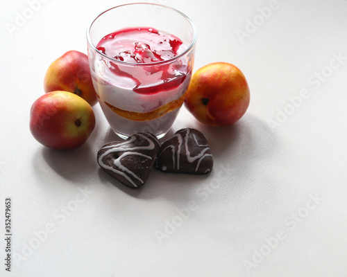 cottage cheese dessert in a glass, nectarines and gingerbreads on a white background close-up