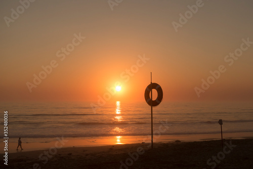 sunset on the beach, Praia da Areia Branca beach, near Lourinha on the Portuguese silver coast.  photo