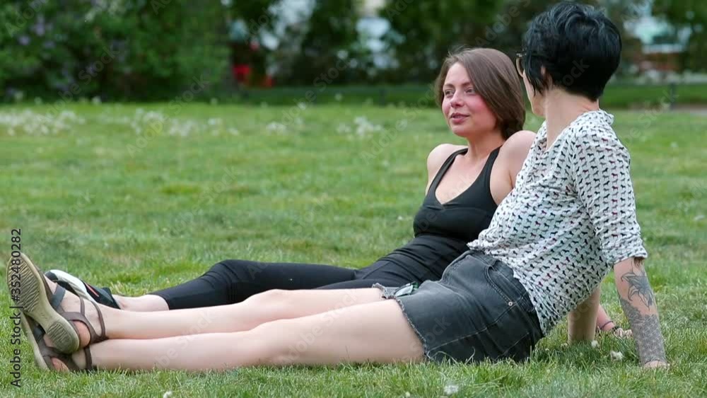 Two women sitting in a park talking. Speech communication, spontaneous communication between two people. Two women sitting in a park talking. Speech communication, spontaneous communication between two people.