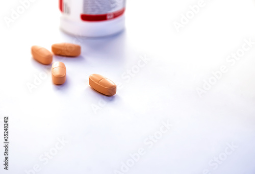 Yellow pill out from plastic jar on white background. Virus protection concept. Copy space. 